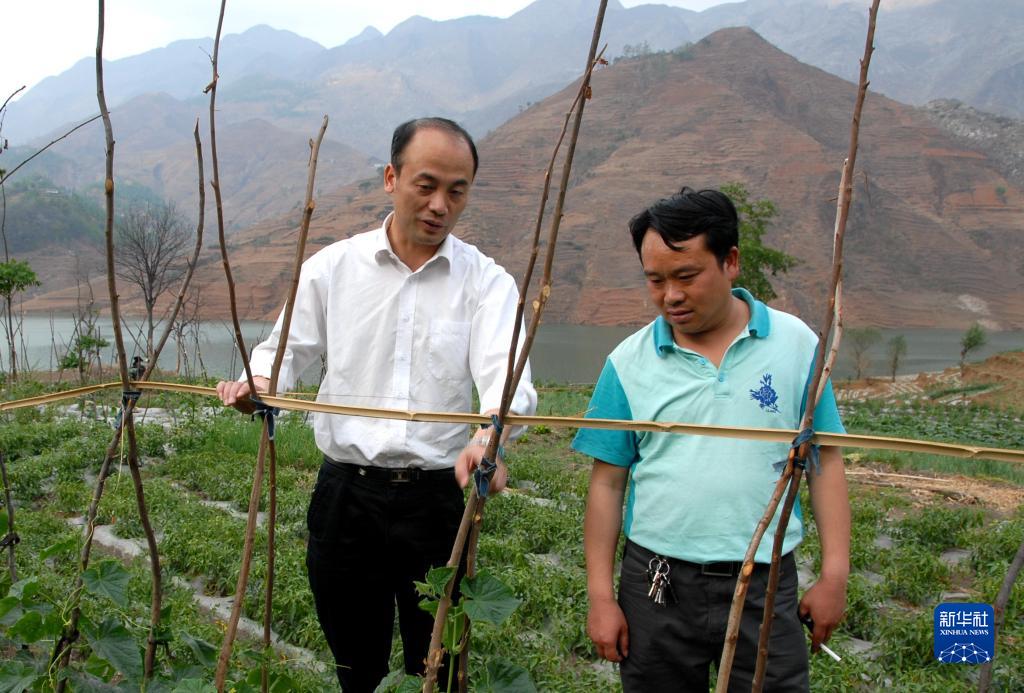 姜仕坤（左）在貴州晴隆縣長流鄉(xiāng)與村民交流（資料照片）。新華社發(fā)